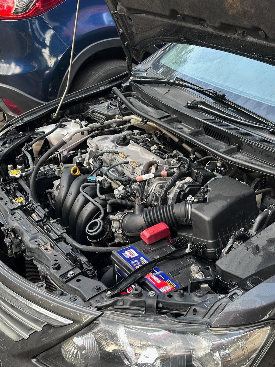 A technician attending to a car in an automotive workshop