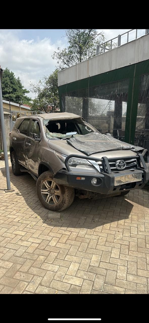 Mechanic measuring brake pad thickness with calipers on a lifted vehicle
